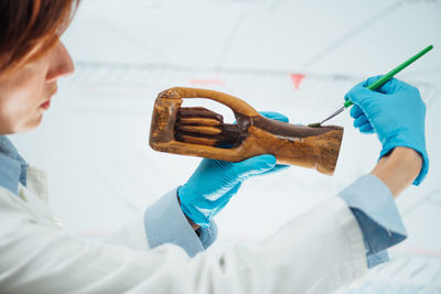 Professional female conservator explaining wooden sculpture restoration