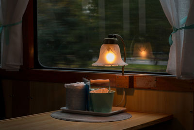 Close-up of illuminated lamp on table in train