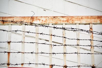 Rusty metal fence against wall