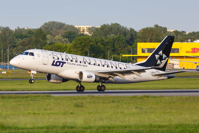 Side view of airplane on airport runway against sky