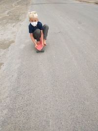Boy wearing mask skateboarding down a street