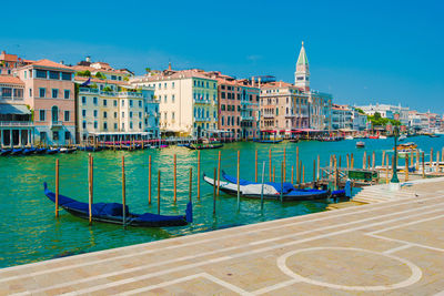 Sailboats in canal against buildings in city