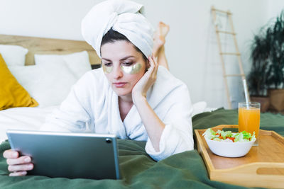 Midsection of woman using mobile phone while sitting on table