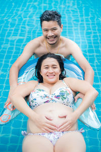 Portrait of a smiling young woman swimming pool