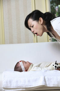 Close-up of mother playing with crying daughter at home