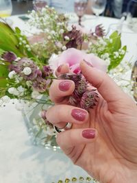 Cropped hand holding flower in vase