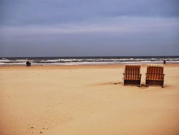 Scenic view of beach against cloudy sky