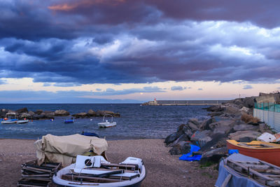 People at beach against cloudy sky