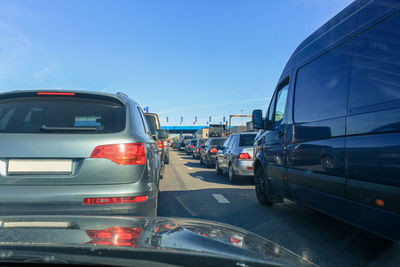 Traffic on road in city against clear blue sky