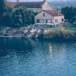 Houses by swimming pool by lake against trees