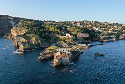 High angle view of townscape by sea against clear sky