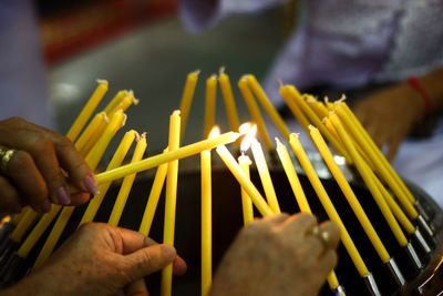 Cropped image of women lighting candles