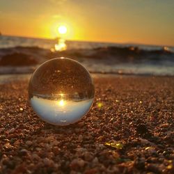 Close-up of ball on beach during sunset