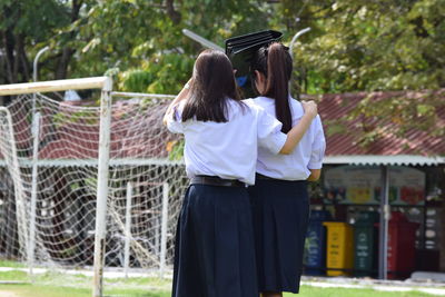 Rear view of women standing outdoors