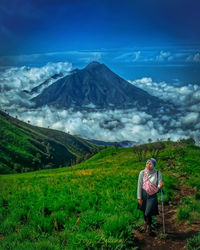 Woman standing on field against mountain range