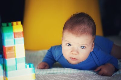 Portrait of cute baby lying on bed at home