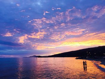 Scenic view of sea against cloudy sky at sunset