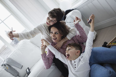 Cheerful mother and sons taking selfie in living room at home