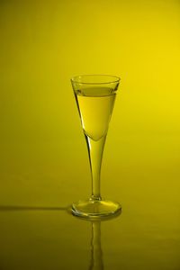 Close-up of wineglass against yellow background