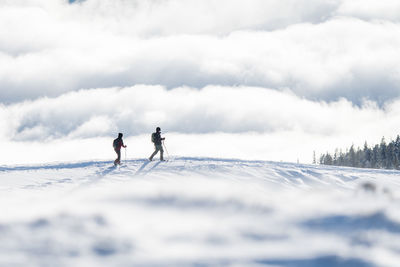 People on snowcapped mountain against sky