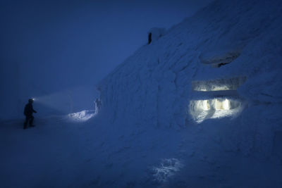 People on snow covered field against snowcapped mountain