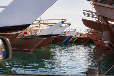 Sailboats moored in sea against sky