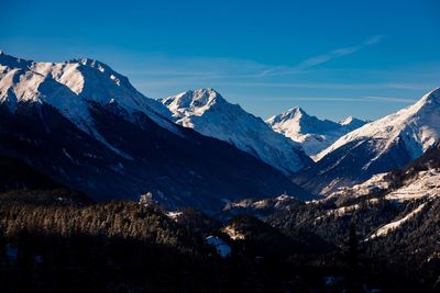 Scenic view of snowcapped mountains against blue sky