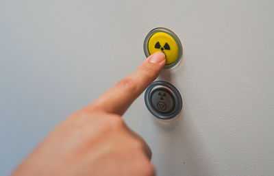 Close-up of hand pressing radioactive warning symbol button 