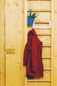 Close-up of red jacket on ladder against restroom sign