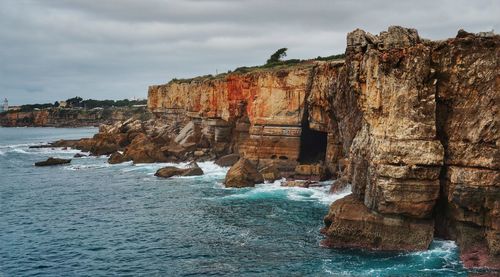 Rock formation on sea against sky