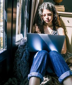 Young woman using mobile phone at home