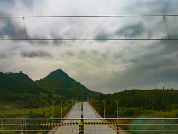 Bridge over mountain against sky