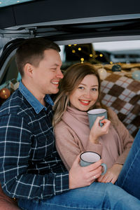 Portrait of smiling friends using mobile phone