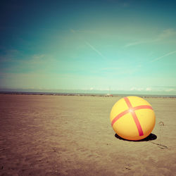 Ball on beach against sky