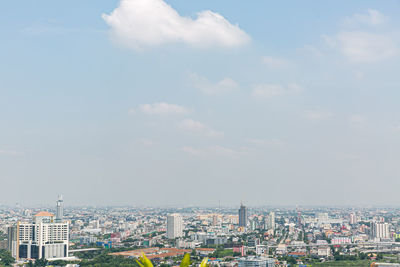 Buildings in city against cloudy sky