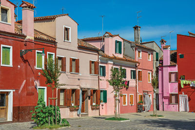 View of colorful houses on sunny day in burano, a gracious little town full of canals in italy.