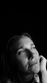 Portrait of man looking away against black background