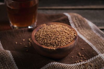 Bowl of fenugreek seeds and egyptian fenugreek yellow tea or methi dana drink