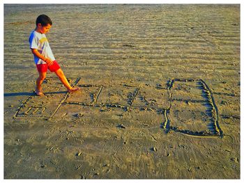 Side view of boy playing on hopscotch