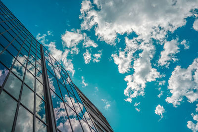 Low angle view of glass building against sky