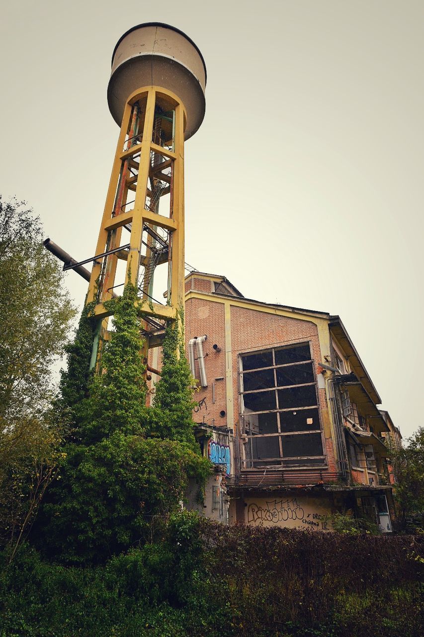 built structure, architecture, building exterior, sky, plant, tree, low angle view, nature, day, no people, clear sky, water tower - storage tank, building, outdoors, old, tower, window, ladder, storage tank, tall - high, water conservation