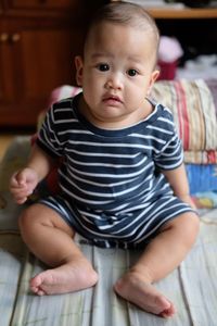 Portrait of cute baby girl sitting at home