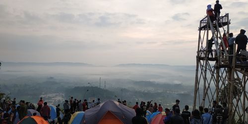 People on mountain against sky