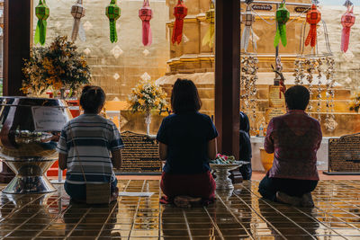 Rear view of people sitting outside building