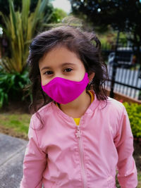 Portrait of girl standing with pink mask