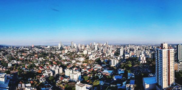 High angle view of modern buildings against blue sky