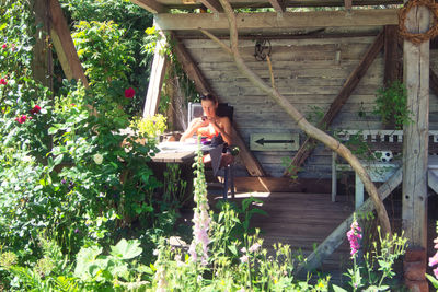 Woman by flower plants in yard