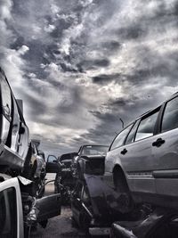 Cars on road against cloudy sky