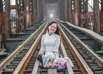 Portrait of smiling woman on railroad tracks