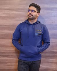 Portrait of young man standing against wall